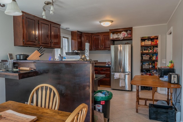 kitchen featuring light tile patterned floors, open shelves, crown molding, dark countertops, and freestanding refrigerator