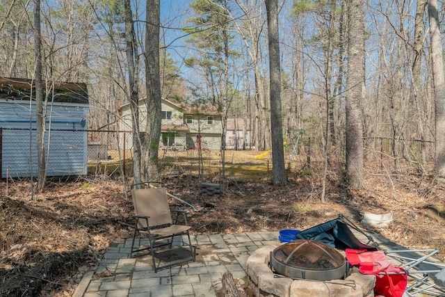 view of yard featuring a fire pit, fence, and a patio area