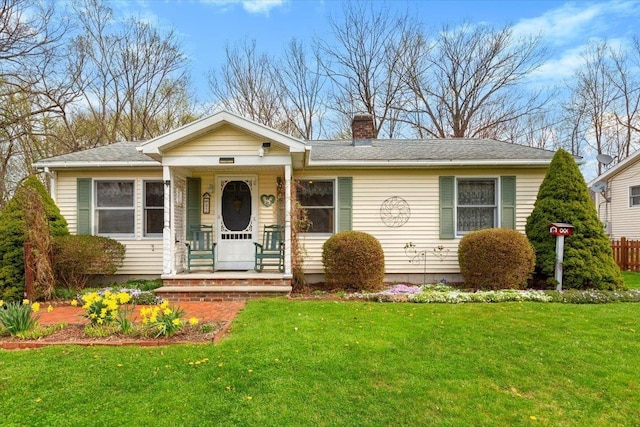 single story home featuring a chimney and a front lawn