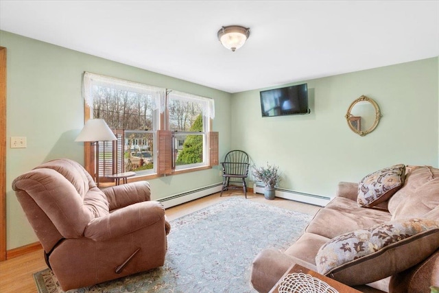 living area with baseboard heating, baseboards, and wood finished floors