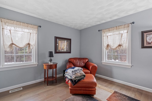 living area featuring visible vents, wood finished floors, and plenty of natural light