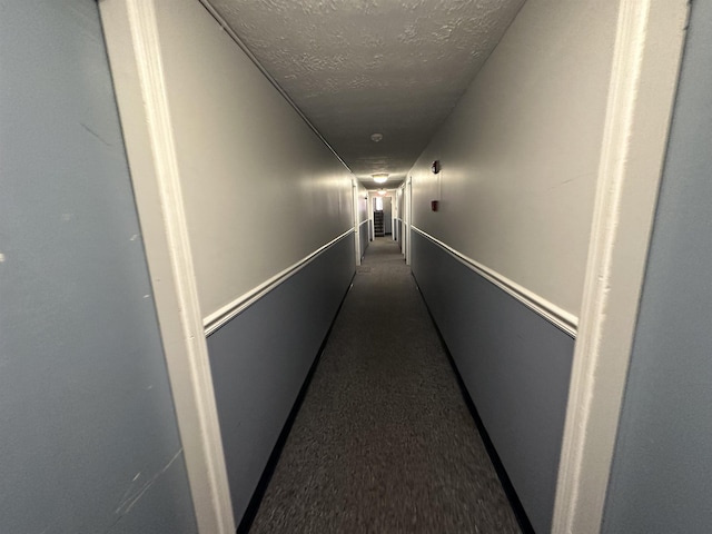 hallway featuring a textured ceiling and carpet floors