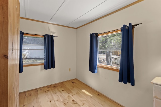 empty room with crown molding and hardwood / wood-style flooring