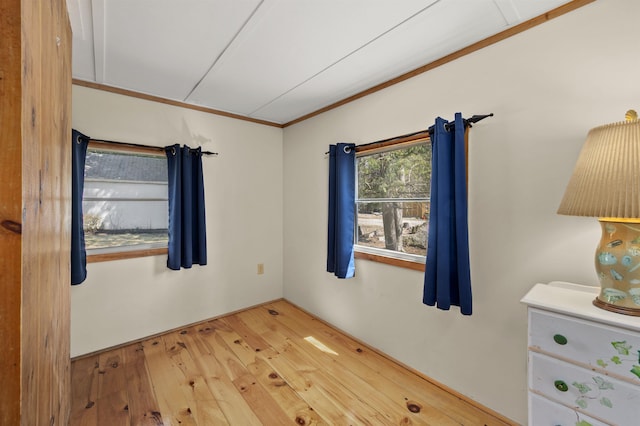 unfurnished room with hardwood / wood-style flooring and ornamental molding