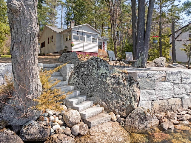exterior space featuring a sunroom and stairs