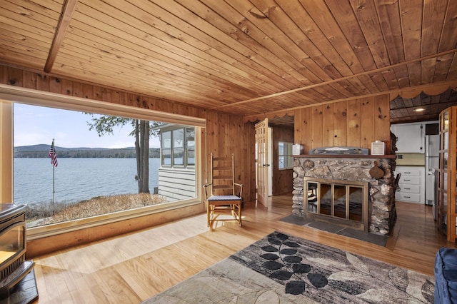 interior space featuring wooden walls, hardwood / wood-style floors, a water view, and wooden ceiling