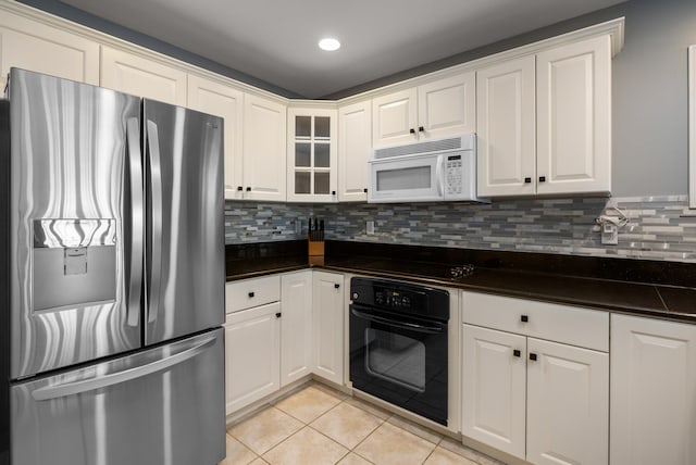 kitchen featuring light tile patterned floors, white cabinetry, decorative backsplash, dark countertops, and black appliances