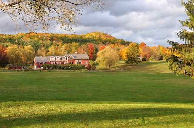 surrounding community with a lawn and a wooded view