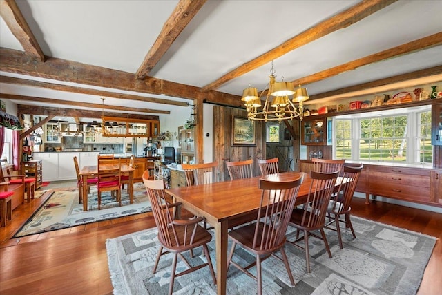 dining room featuring a notable chandelier, beam ceiling, and wood finished floors
