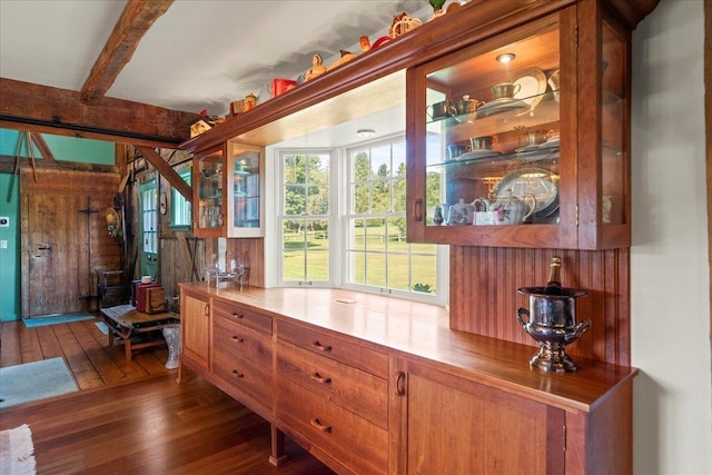 interior space with beam ceiling and wood finished floors