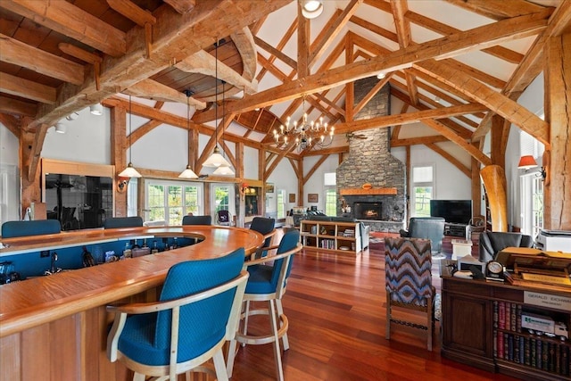 interior space featuring a chandelier, high vaulted ceiling, beamed ceiling, and wood finished floors
