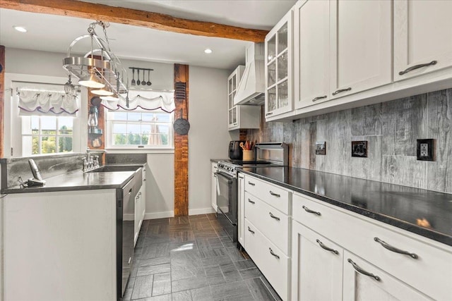 kitchen with a sink, appliances with stainless steel finishes, dark countertops, premium range hood, and recessed lighting