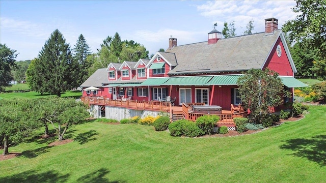 rear view of house featuring a deck and a yard