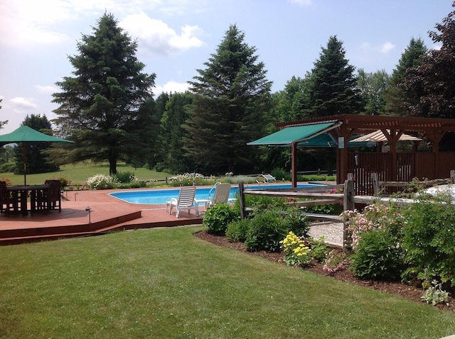 outdoor pool featuring a deck and a lawn