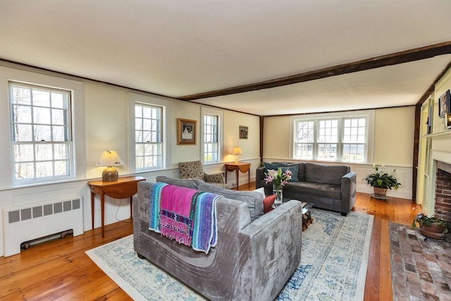 161 Upper Jaffrey Rd, Dublin, NH 03444 - living area featuring a brick fireplace, radiator heating unit, beam ceiling, and hardwood / wood-style flooring