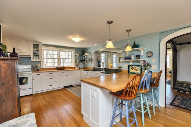 161 Upper Jaffrey Rd, Dublin, NH 03444 - kitchen with white range with electric cooktop, a peninsula, arched walkways, white cabinets, and light wood-type flooring