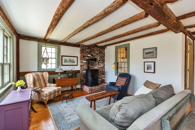 161 Upper Jaffrey Rd, Dublin, NH 03444 - living area with a wood stove, a baseboard radiator, beamed ceiling, and light wood-style floors