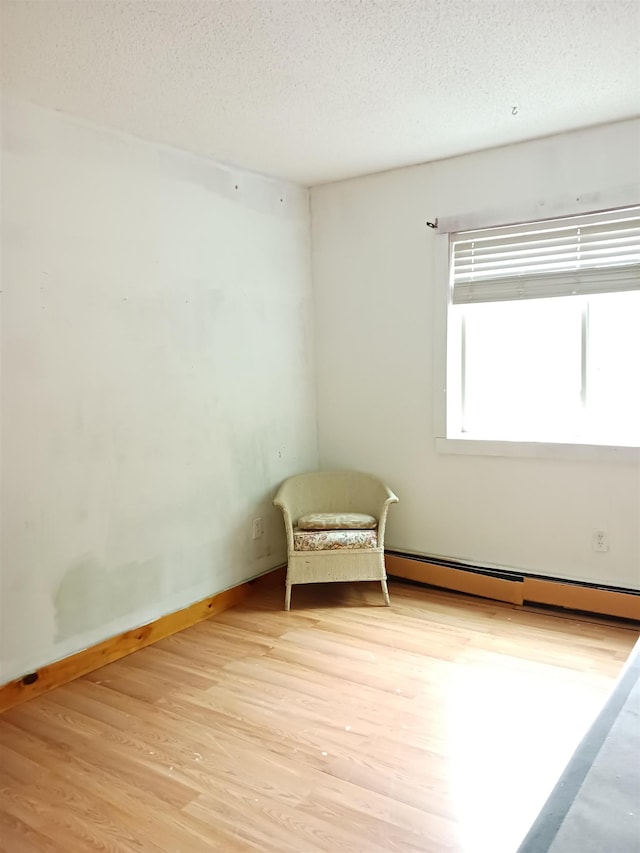 3730 Rte 100, Wardsboro, VT 05355 - empty room featuring light wood finished floors, a textured ceiling, baseboards, and baseboard heating