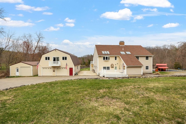 back of property featuring a chimney, an outdoor structure, a yard, roof with shingles, and a detached garage