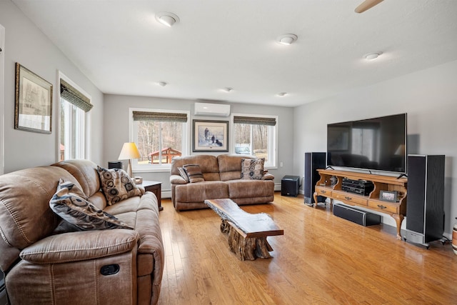 living area featuring baseboard heating, wood finished floors, and an AC wall unit