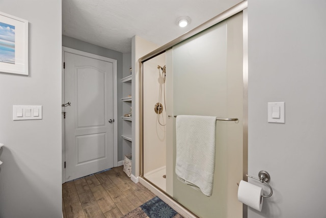 full bath with wood finished floors and a stall shower