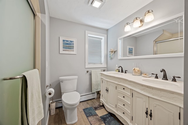 full bathroom featuring baseboard heating, wood finished floors, toilet, and a sink