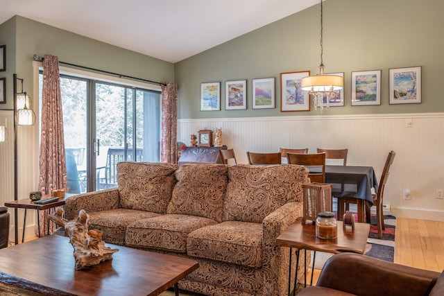 living room featuring baseboards, wainscoting, wood finished floors, and lofted ceiling