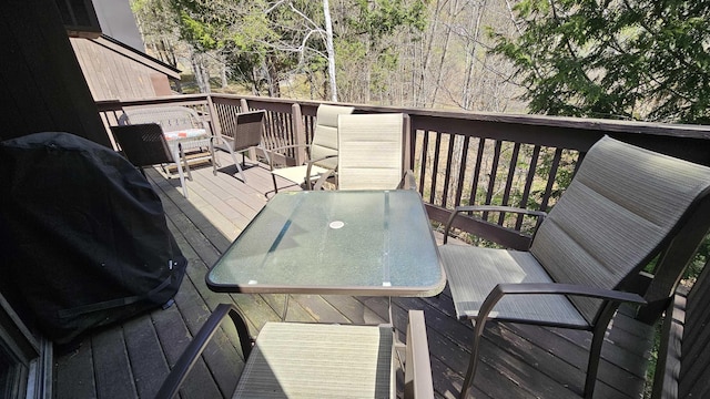 wooden terrace featuring outdoor dining area and a grill