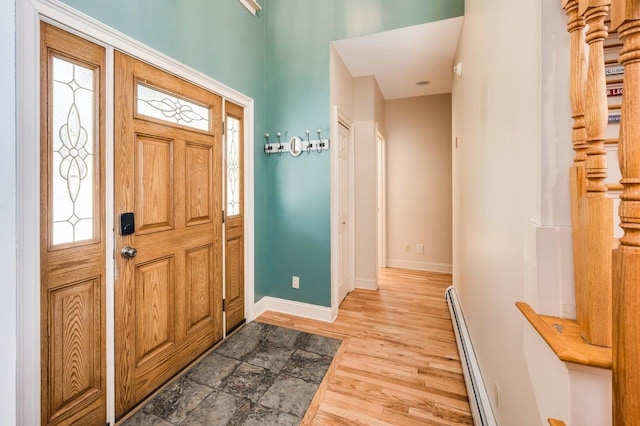 entryway featuring baseboards, wood finished floors, and a baseboard radiator