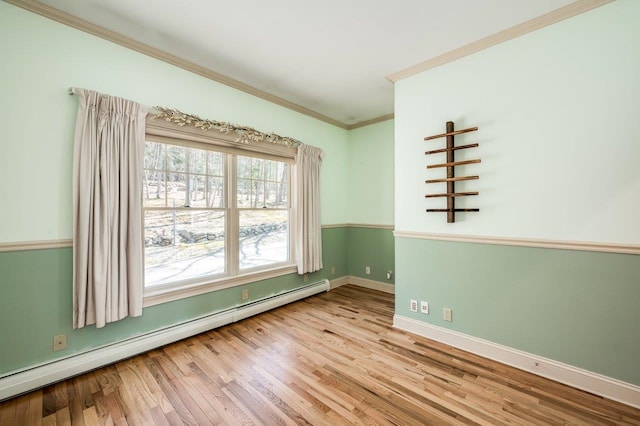unfurnished room with a baseboard radiator, wood finished floors, crown molding, and baseboards