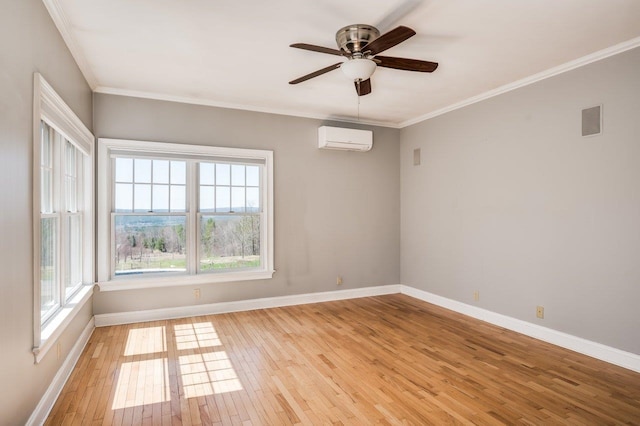 spare room with an AC wall unit, light wood-style flooring, and baseboards