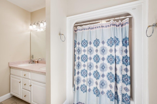 bathroom with double vanity, curtained shower, tile patterned floors, and a sink