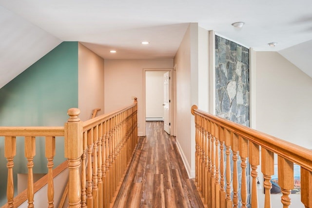 corridor featuring an upstairs landing, baseboard heating, recessed lighting, vaulted ceiling, and wood finished floors