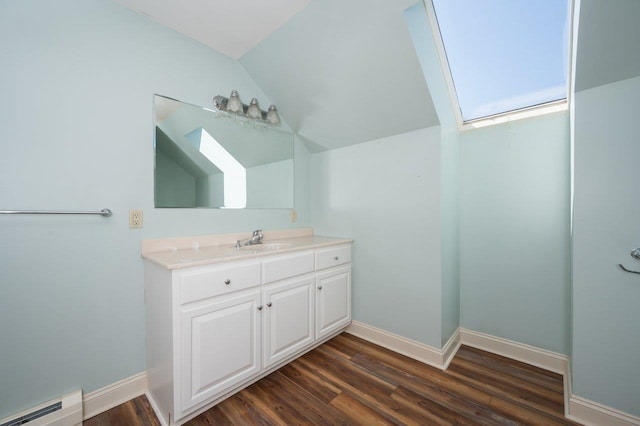 bathroom with baseboard heating, baseboards, wood finished floors, and lofted ceiling