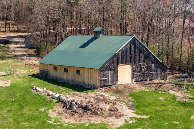 view of outbuilding featuring an outdoor structure and a forest view