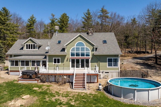 rear view of property with a chimney, stairway, a wooden deck, and a shingled roof