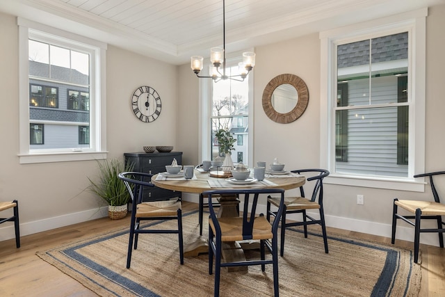 dining area featuring ornamental molding, a chandelier, wood finished floors, and baseboards