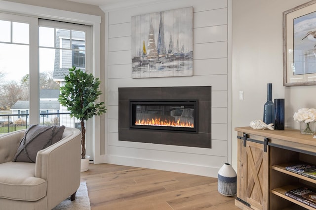 interior space with a glass covered fireplace and light wood-type flooring