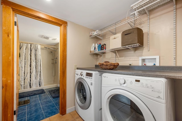 clothes washing area featuring visible vents, baseboards, washer and clothes dryer, tile patterned floors, and laundry area
