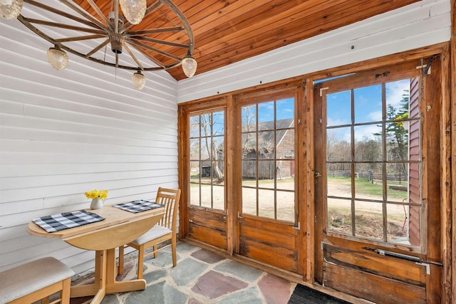 doorway to outside featuring lofted ceiling, stone flooring, and wooden ceiling