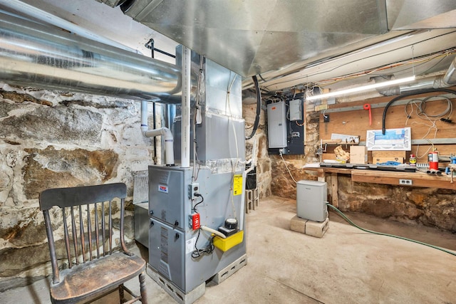 utility room with heating unit and electric panel