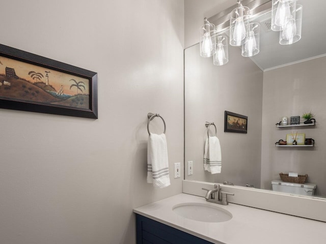 half bath with vanity, ornamental molding, and toilet
