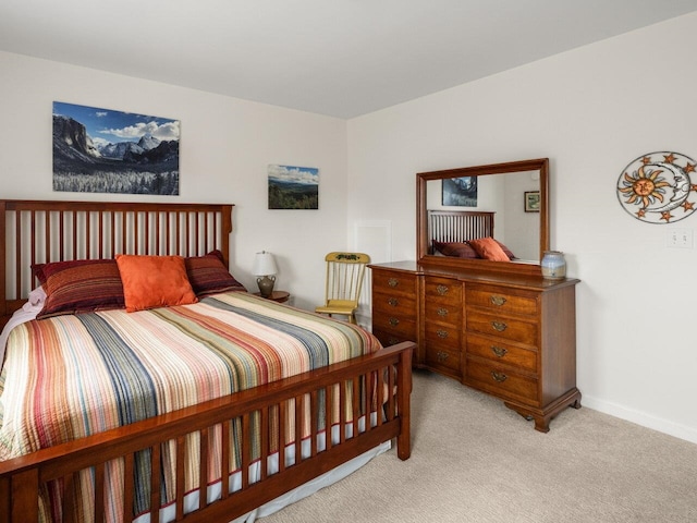 bedroom with baseboards and light carpet