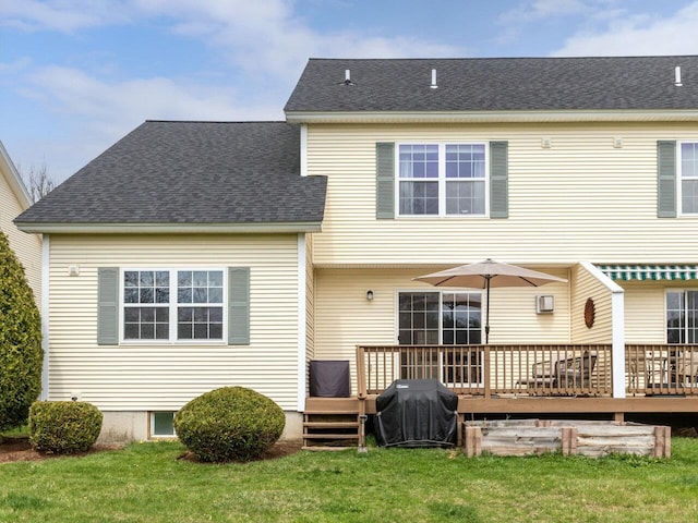 rear view of property with a lawn, a shingled roof, and a wooden deck