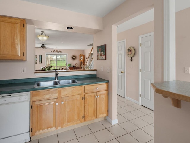 kitchen featuring white dishwasher, dark countertops, light tile patterned floors, and a sink