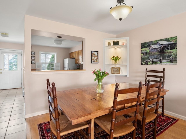 dining room with baseboards and light wood-style flooring