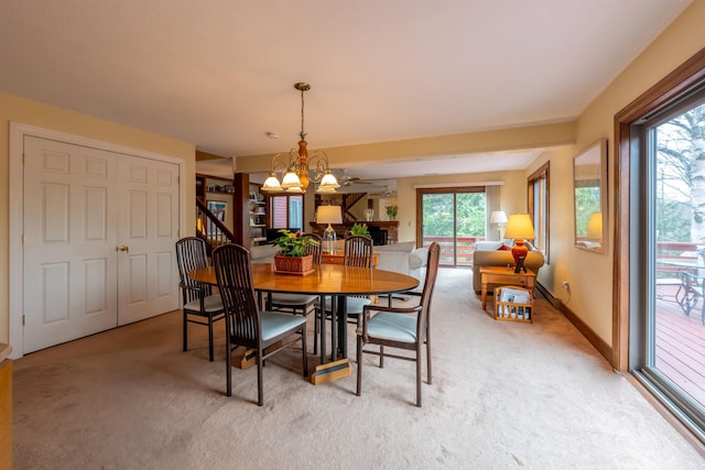 dining area featuring a notable chandelier, light colored carpet, and baseboards