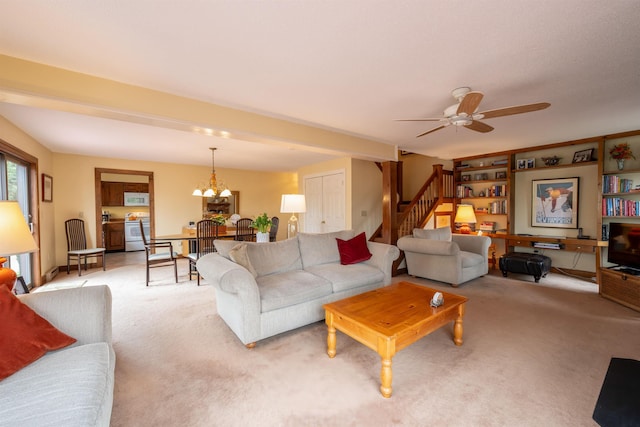 living room featuring stairway, ceiling fan with notable chandelier, and light colored carpet