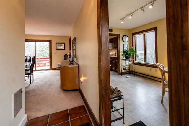 corridor with a baseboard heating unit and baseboards