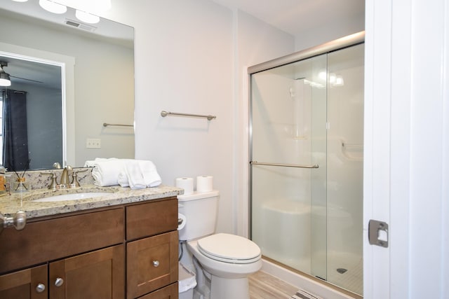 bathroom featuring toilet, visible vents, and a shower stall